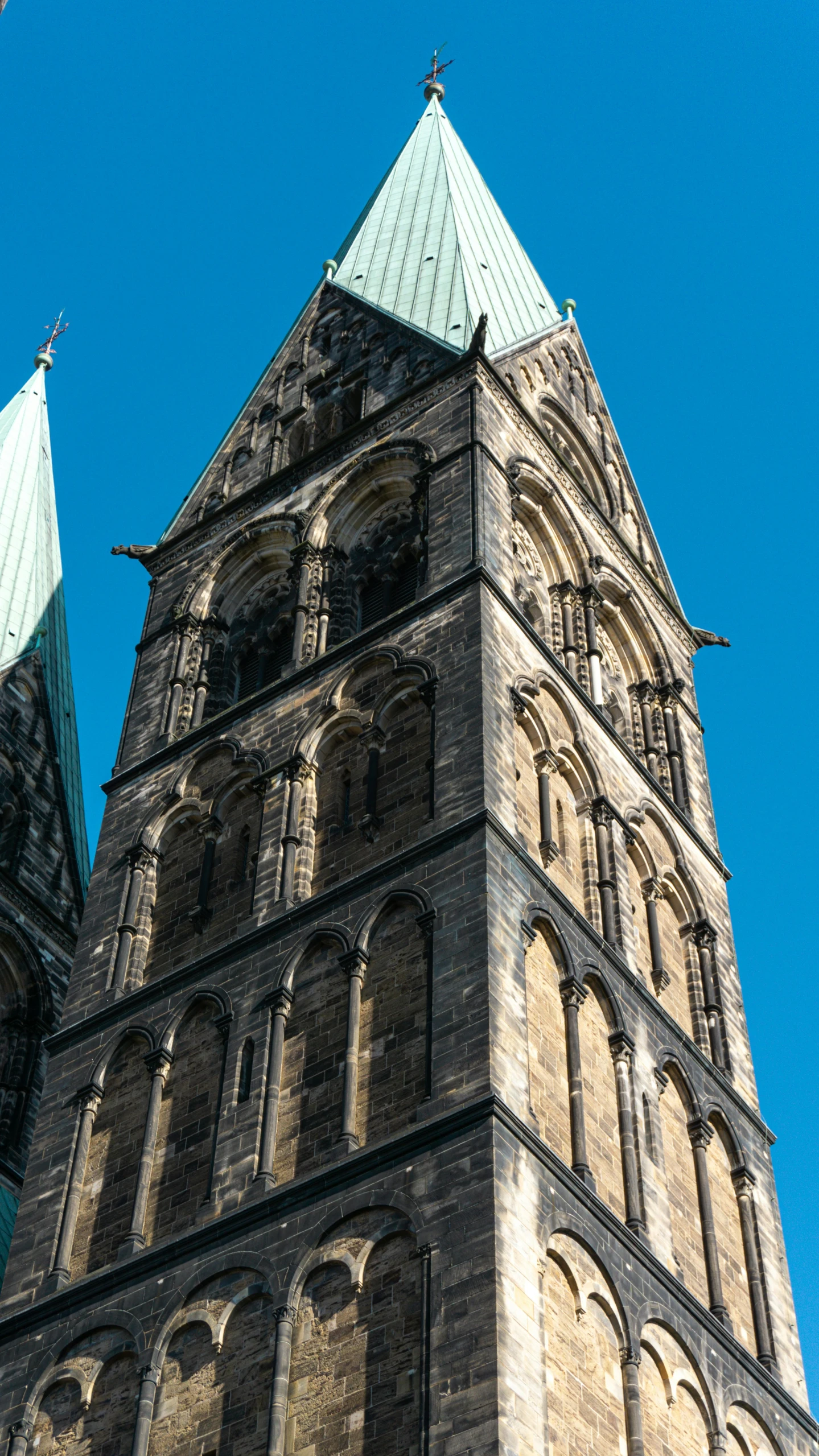 the tower of an old church is adorned with green tiles