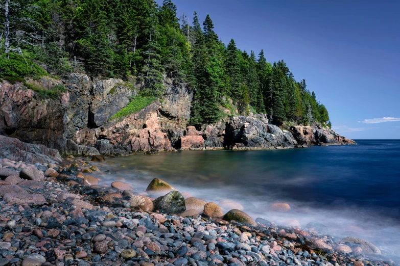 a very pretty rocky beach with some trees