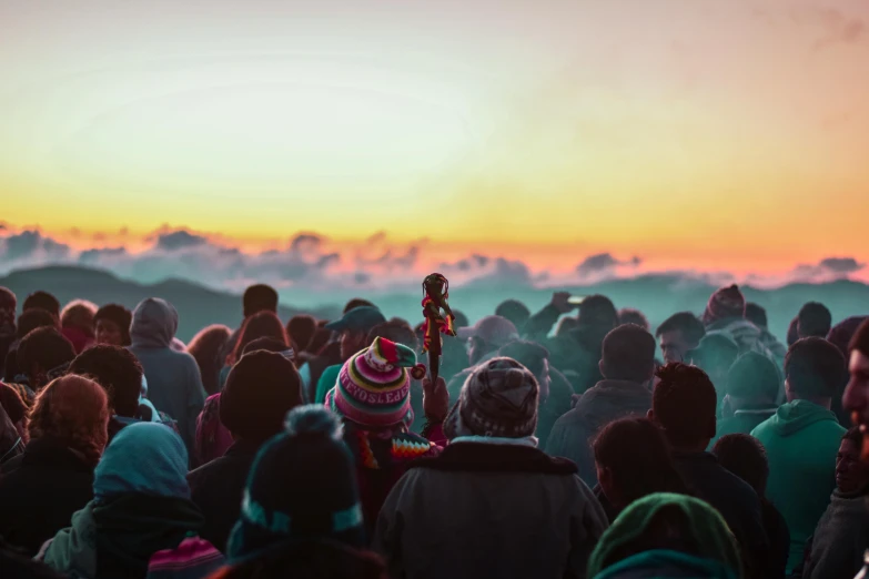 a crowd of people gathered together at sunset