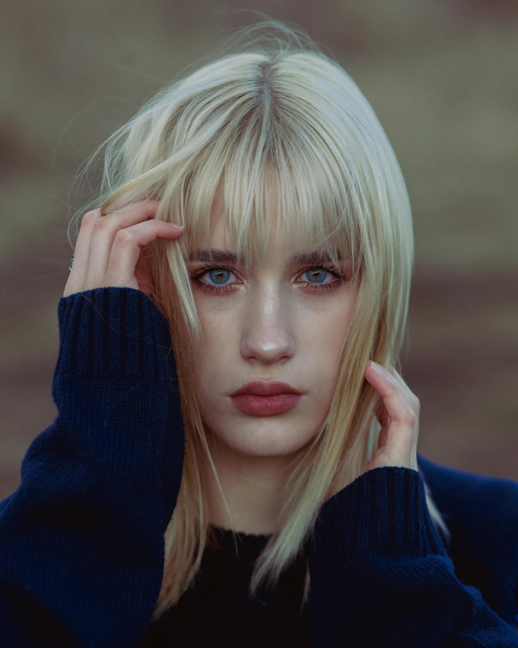 a woman with blonde hair is holding her hands to her head