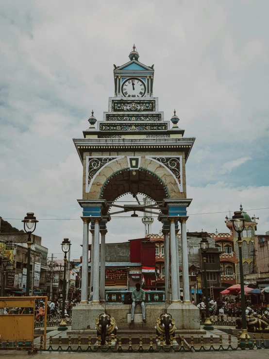 a clock tower is shown near people and buildings