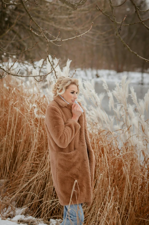 woman standing in snowy field and smoking a cigarette