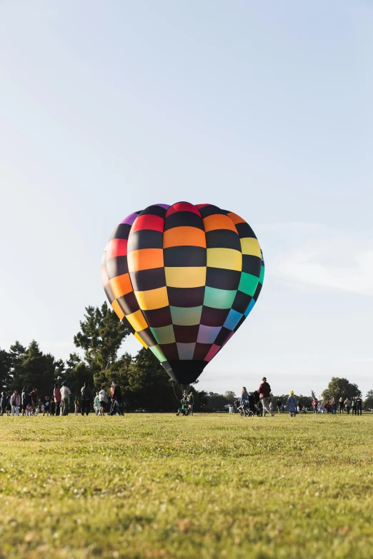 a colorful  air balloon being flown over a field