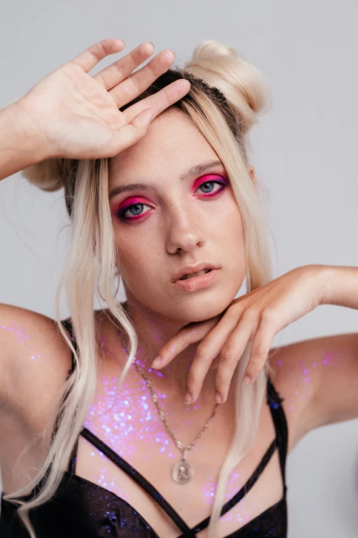 a beautiful blonde with some pink and purple things on her face