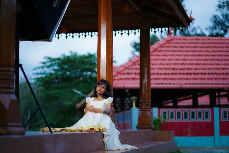 a woman in a white dress sitting on a step