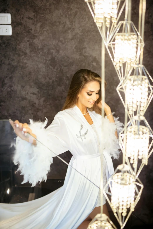 a woman in a white dress with some lights on the wall