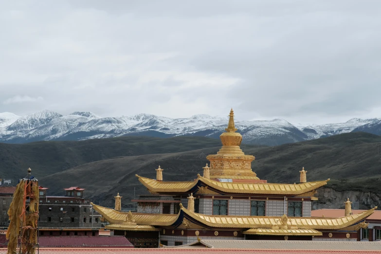 large golden buildings and mountains on a cloudy day