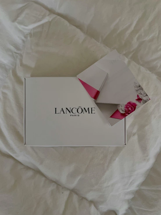 a gift card and some small flowers are laying on a sheet