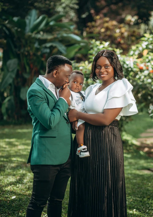 a young black family in their backyard with greenery