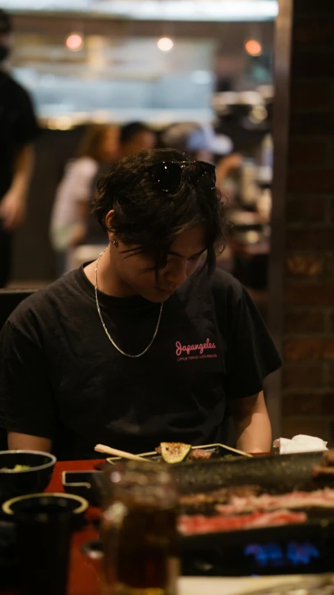 a woman sitting down at a table looking at a cell phone