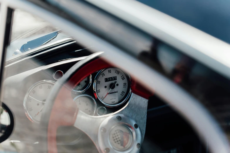 the inside of a car showing a gauge with the door open