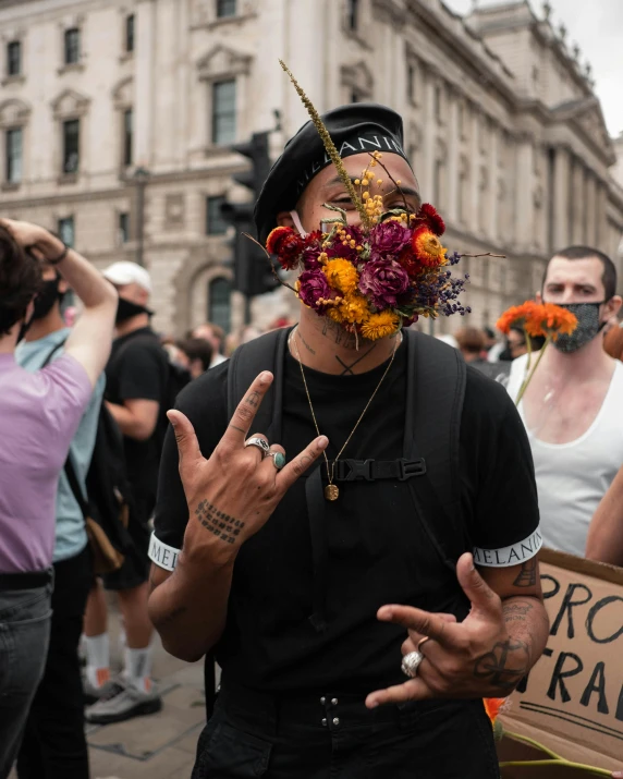 some people with masks and a sign in the middle of town