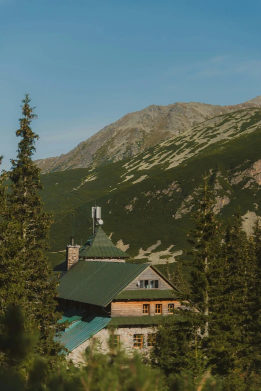 there is a house surrounded by trees on the mountain