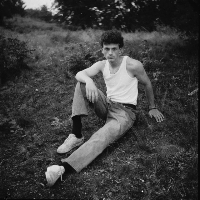 a man sitting in the grass in an open field