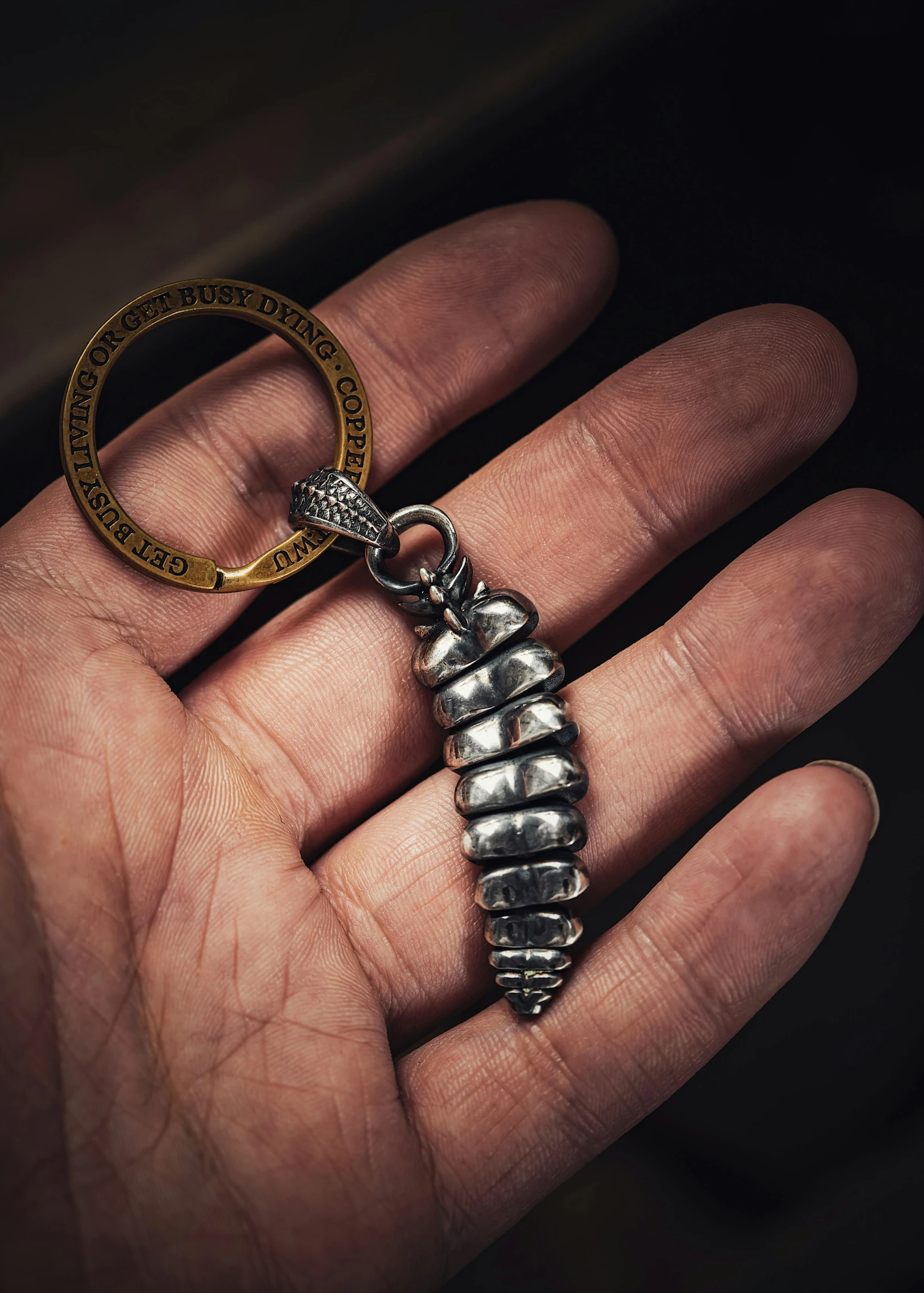 a hand holding a tiny silver metal object