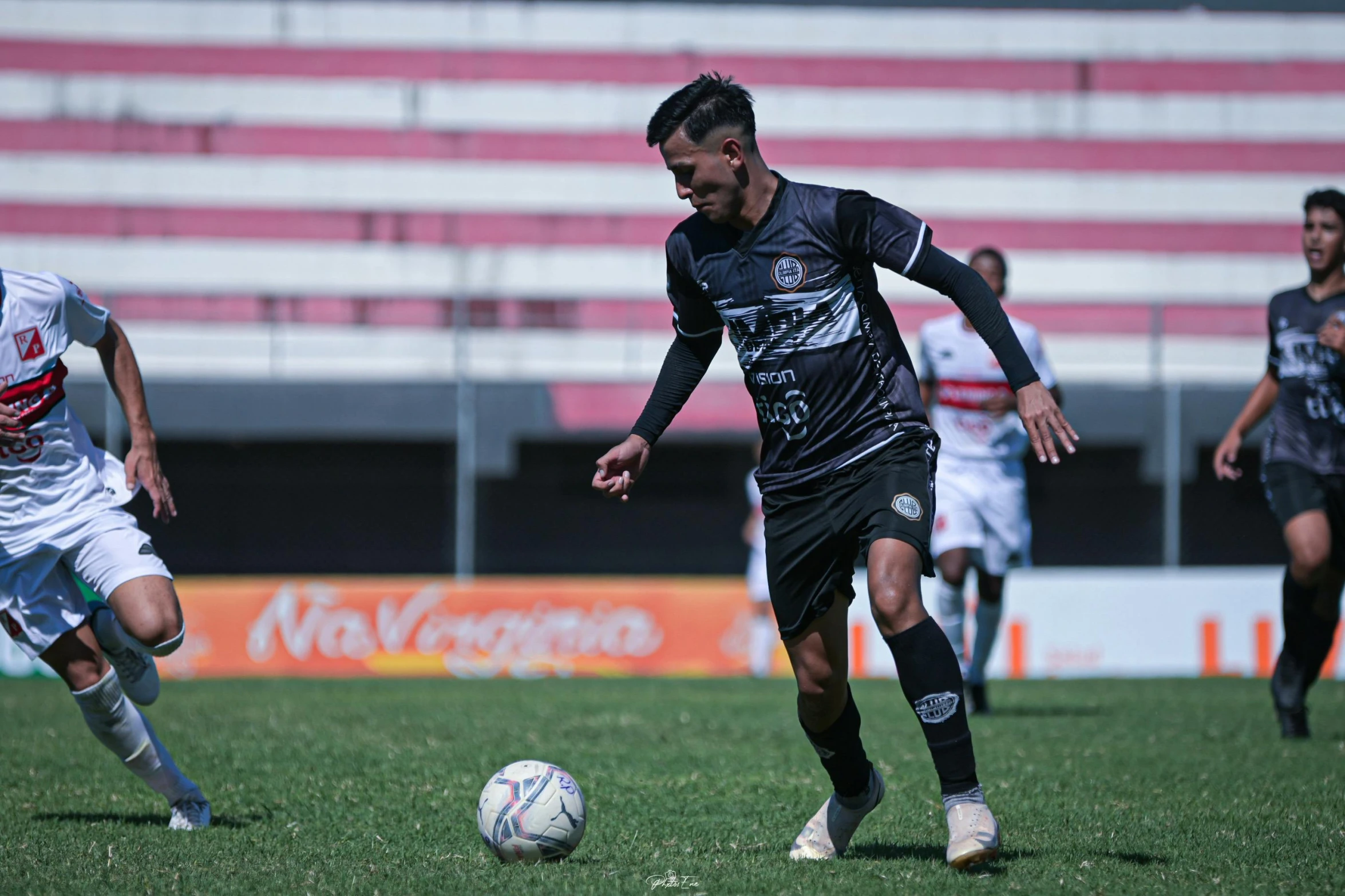 some soccer players running after the ball in a game