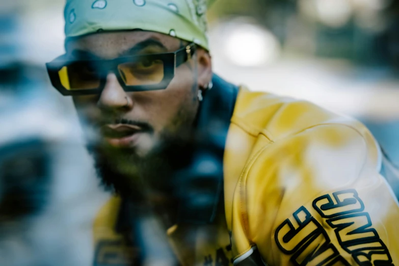 a man in sunglasses and a yellow shirt