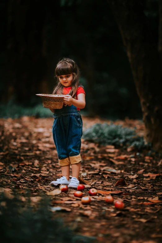 a small girl is holding a basket in her hands