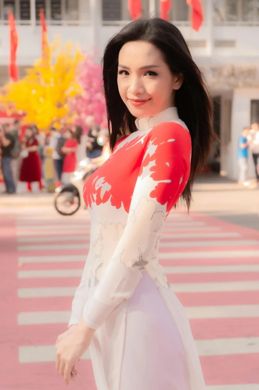 woman in asian outfit posing for picture with red and white background