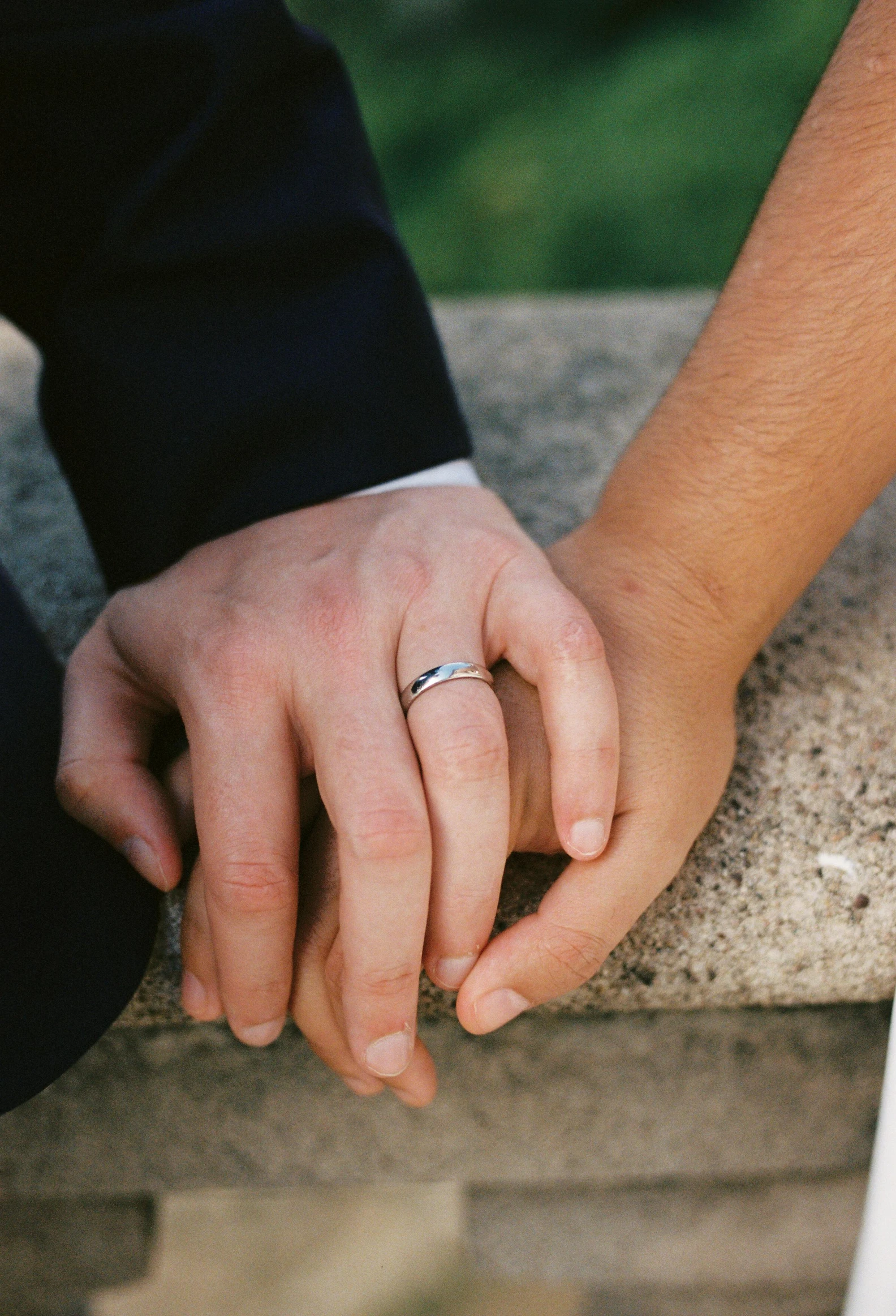 two people are holding hands on a stone bench