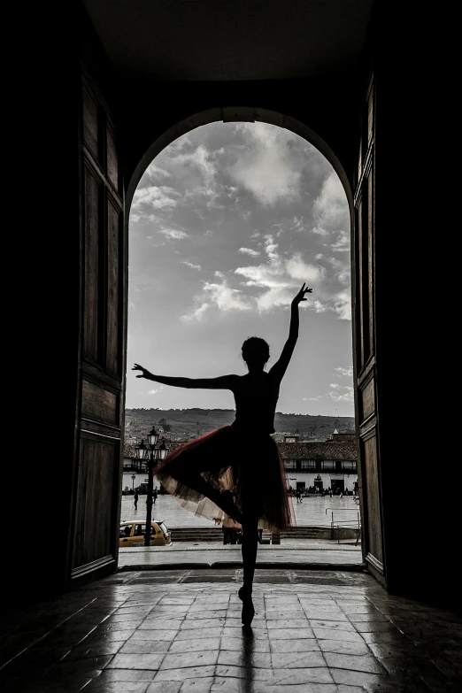 a ballerina stands by an open door