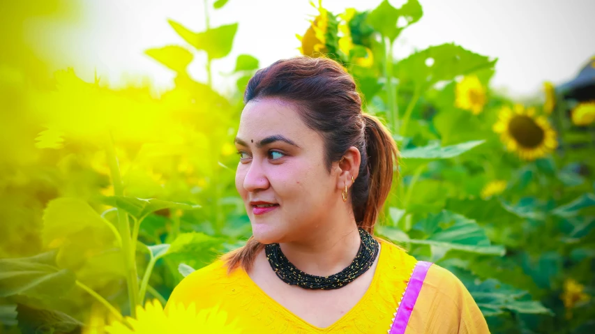 a close up of a person standing in a sunflower field