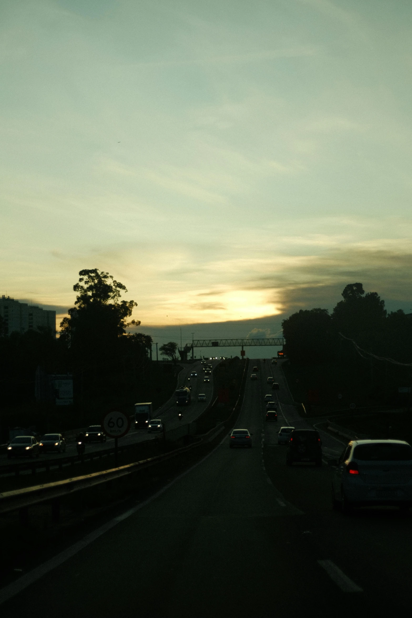 the view of a highway and traffic lights at dusk