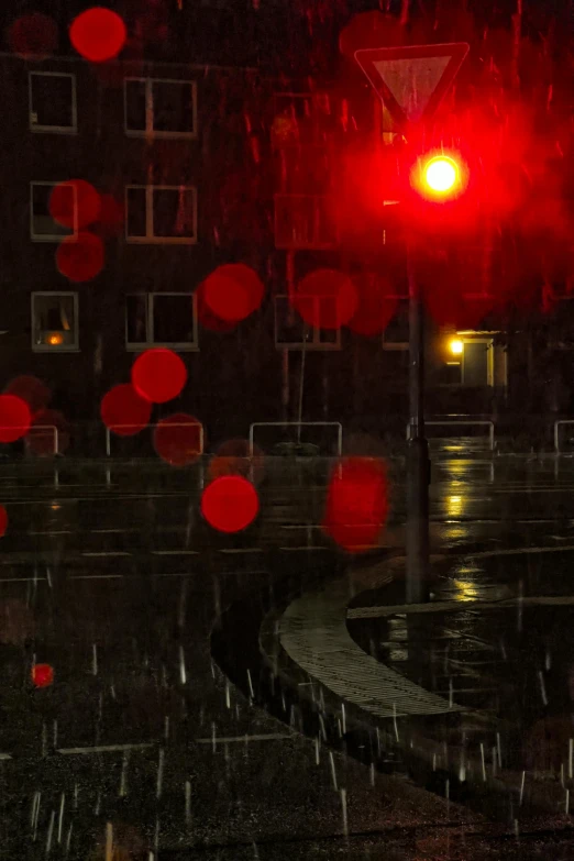 a red traffic light is shining on a night city street