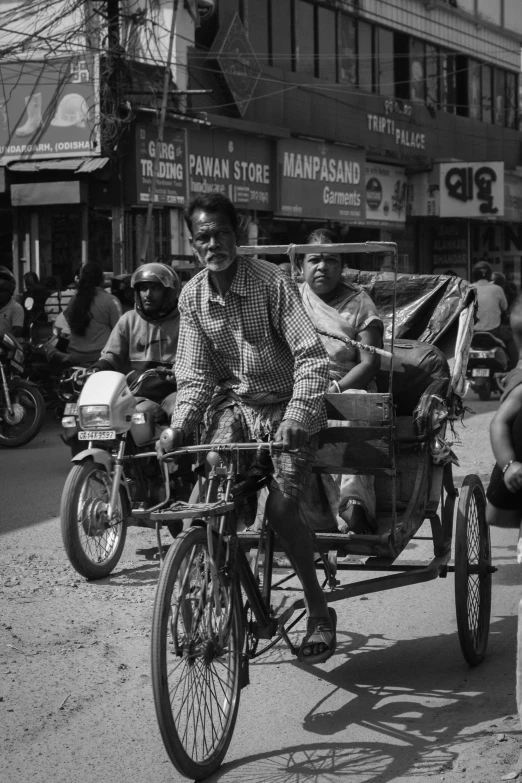 a black and white po of three people driving in an antique motorcycle