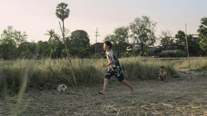 the man is playing with a soccer ball in a field