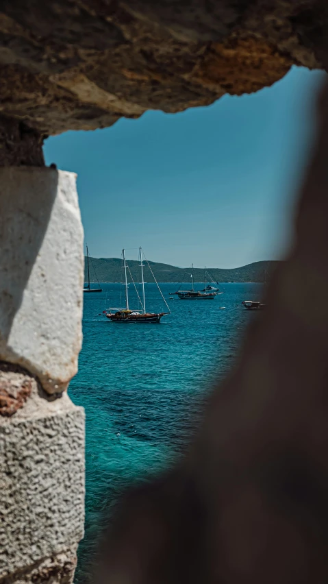 two ships in the water at a pier with rocks