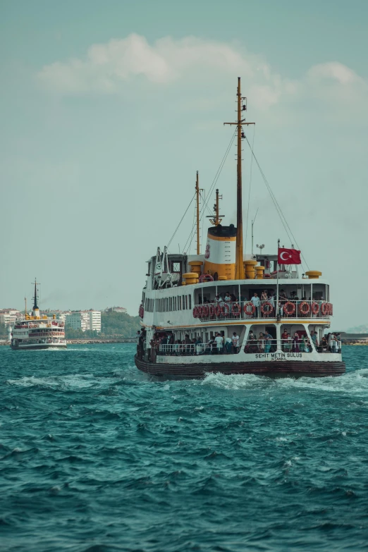 a large ferry with several passengers on it's side in the ocean