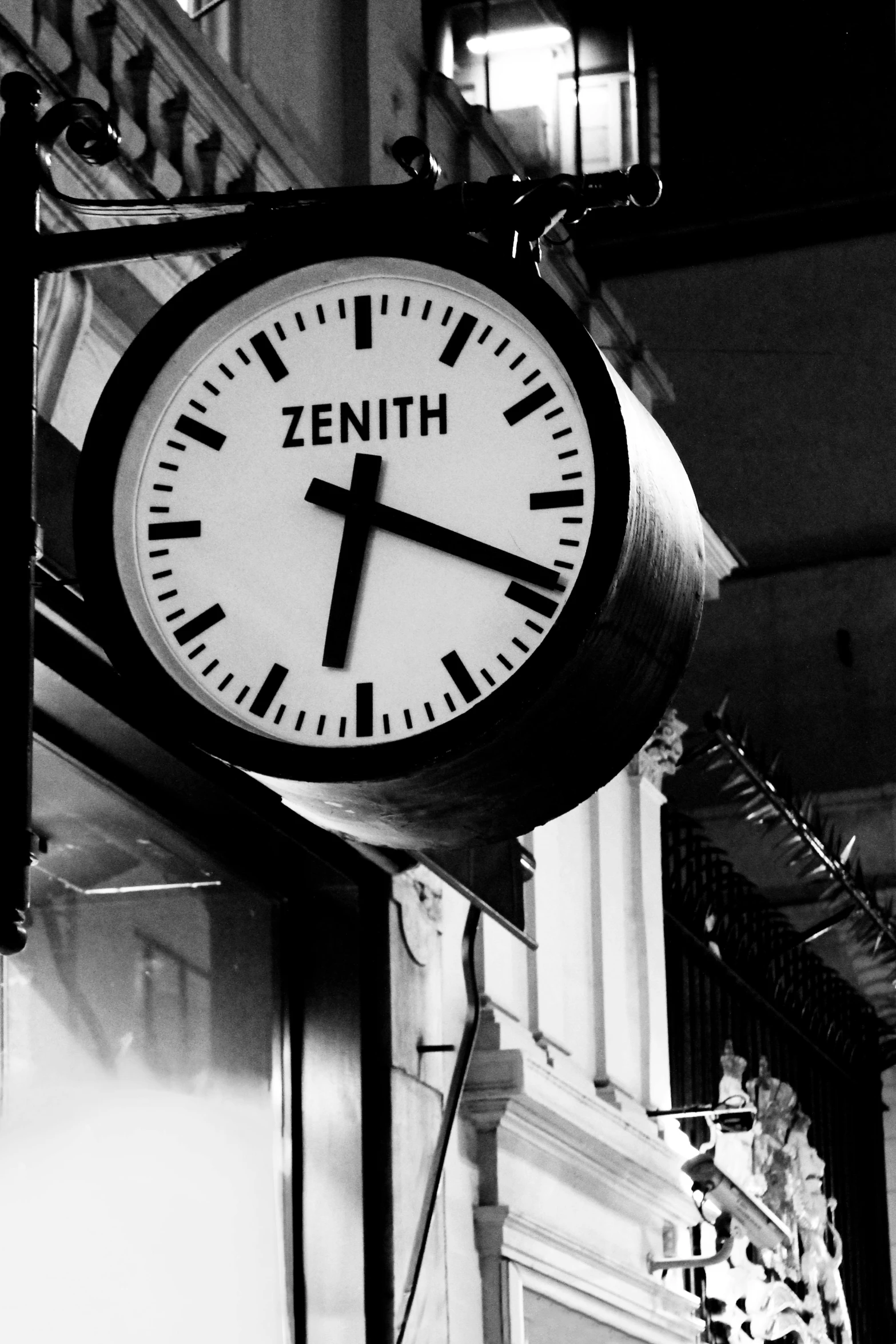 a clock hangs on a building near many other buildings