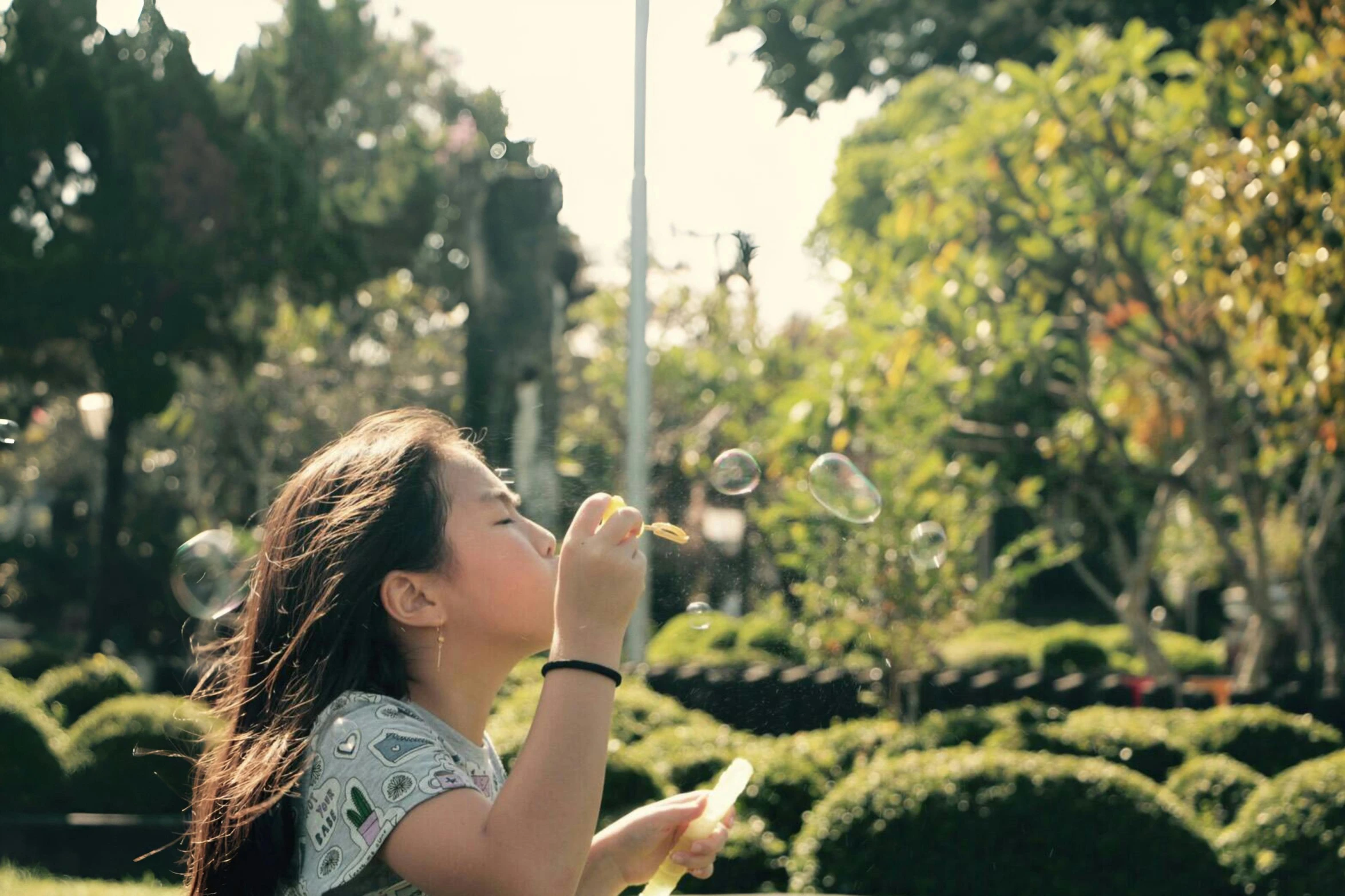 young lady blowing soap bubbles on the ground