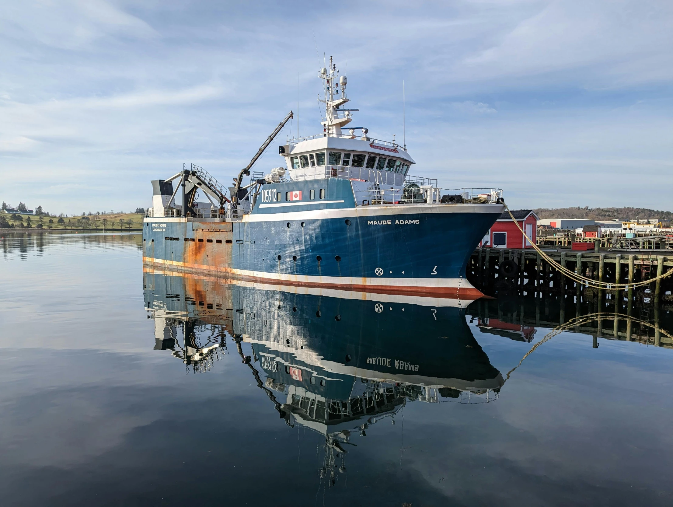 a blue boat is docked at the dock