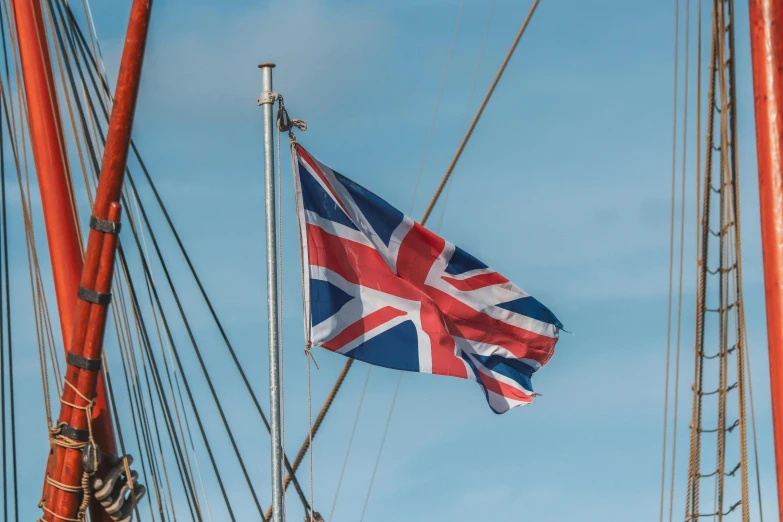 a british flag flies high from the bow of a ship