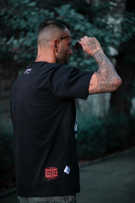 a man with a beard in a black shirt holding a cellphone