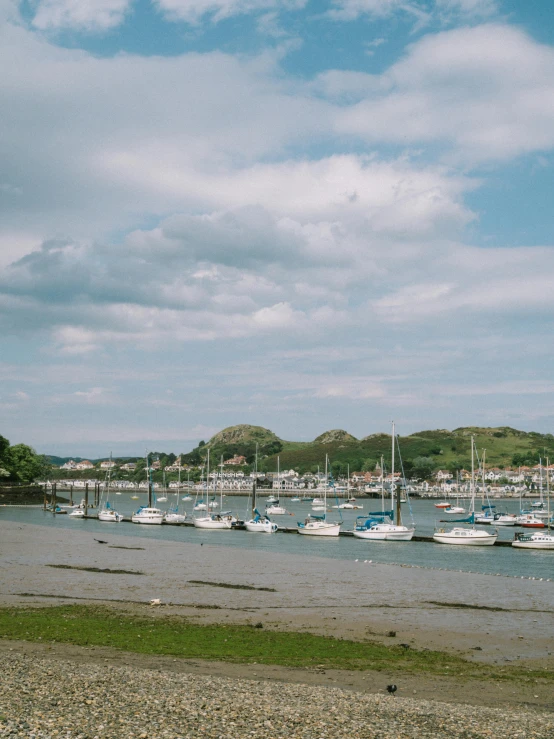 a bay filled with lots of sail boats under a cloudy sky