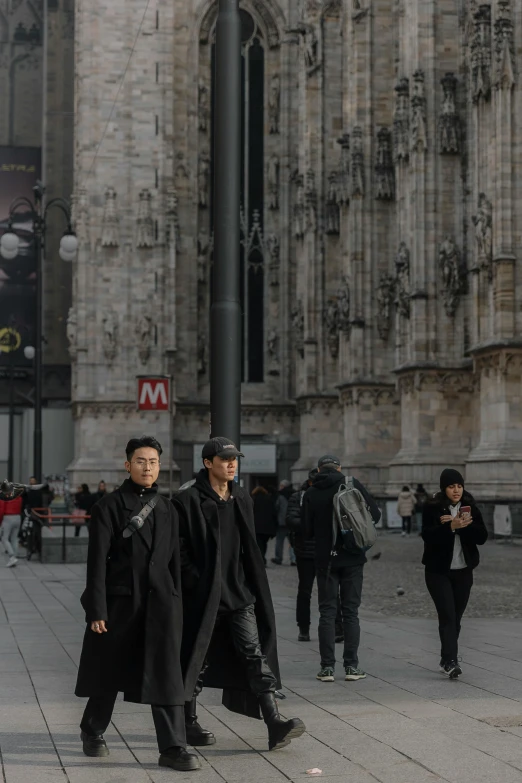 three asian men walking by the cathedral in london