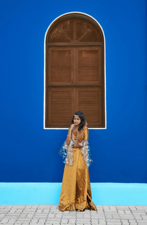 a woman stands next to a blue and bright building