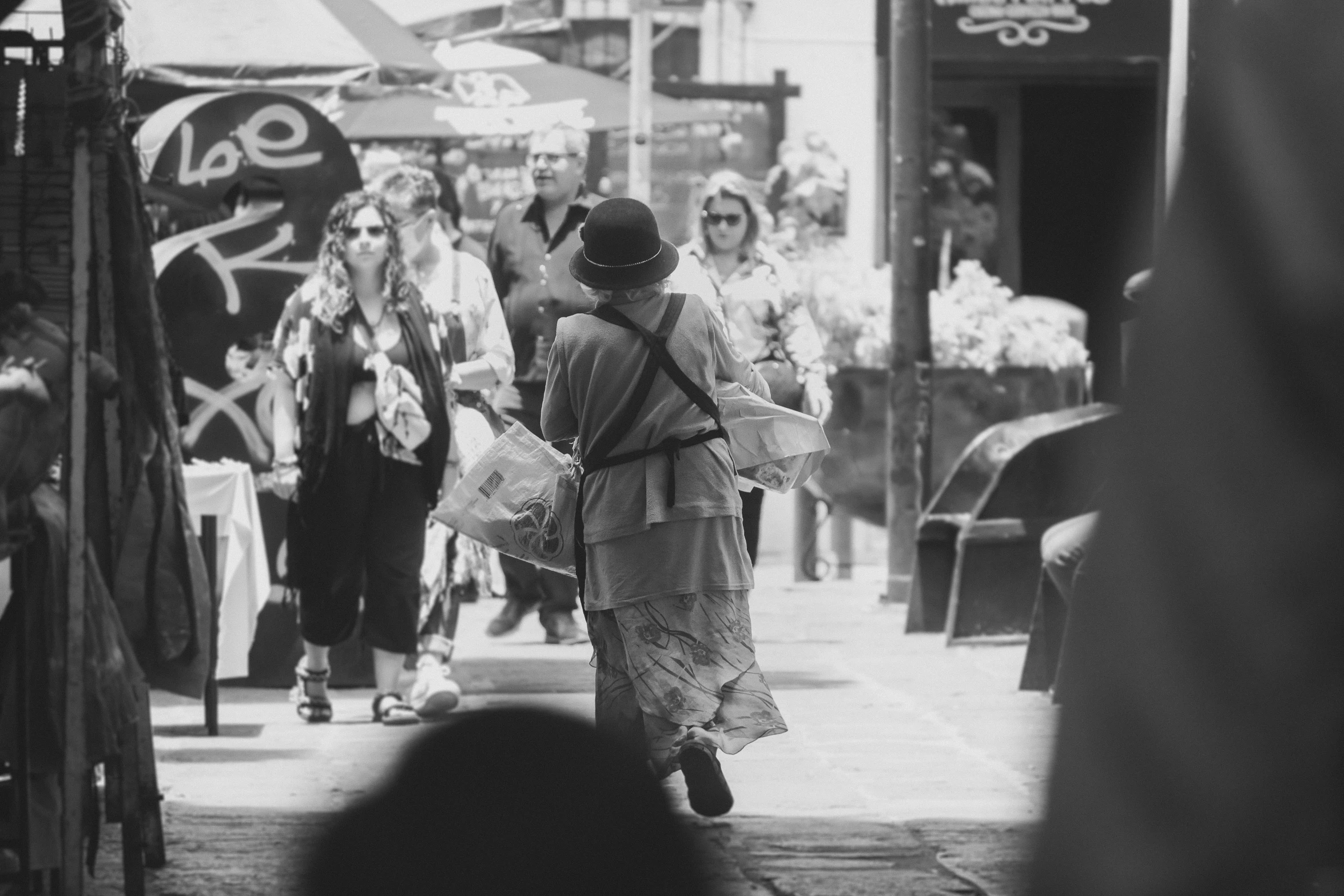 people walking down the street with bags and a few other things