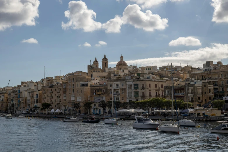 a sea filled with lots of boats near tall buildings