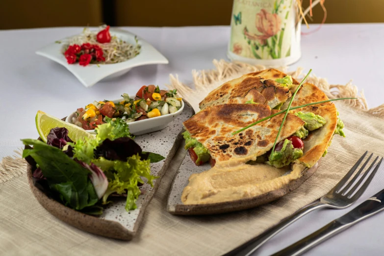 a meal sits on the table near some forks