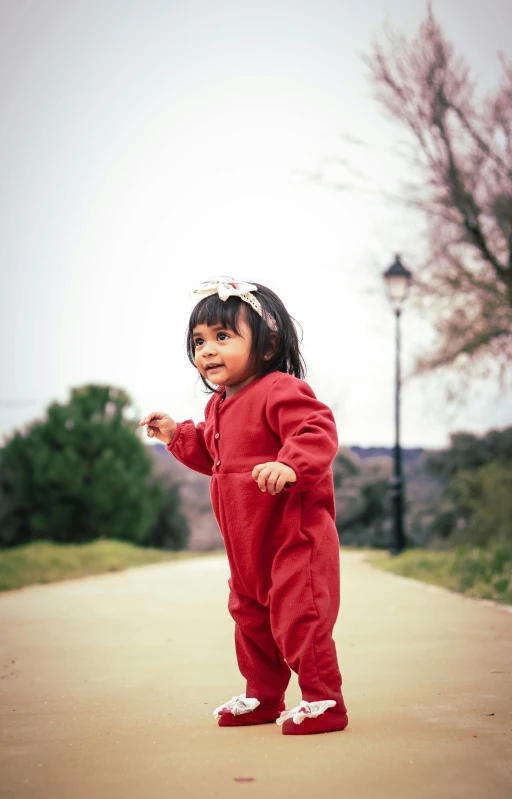 a small child is standing on a road with one foot raised