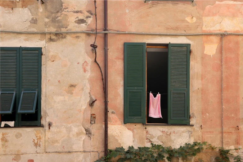 clothes hanging outside a window on an old building