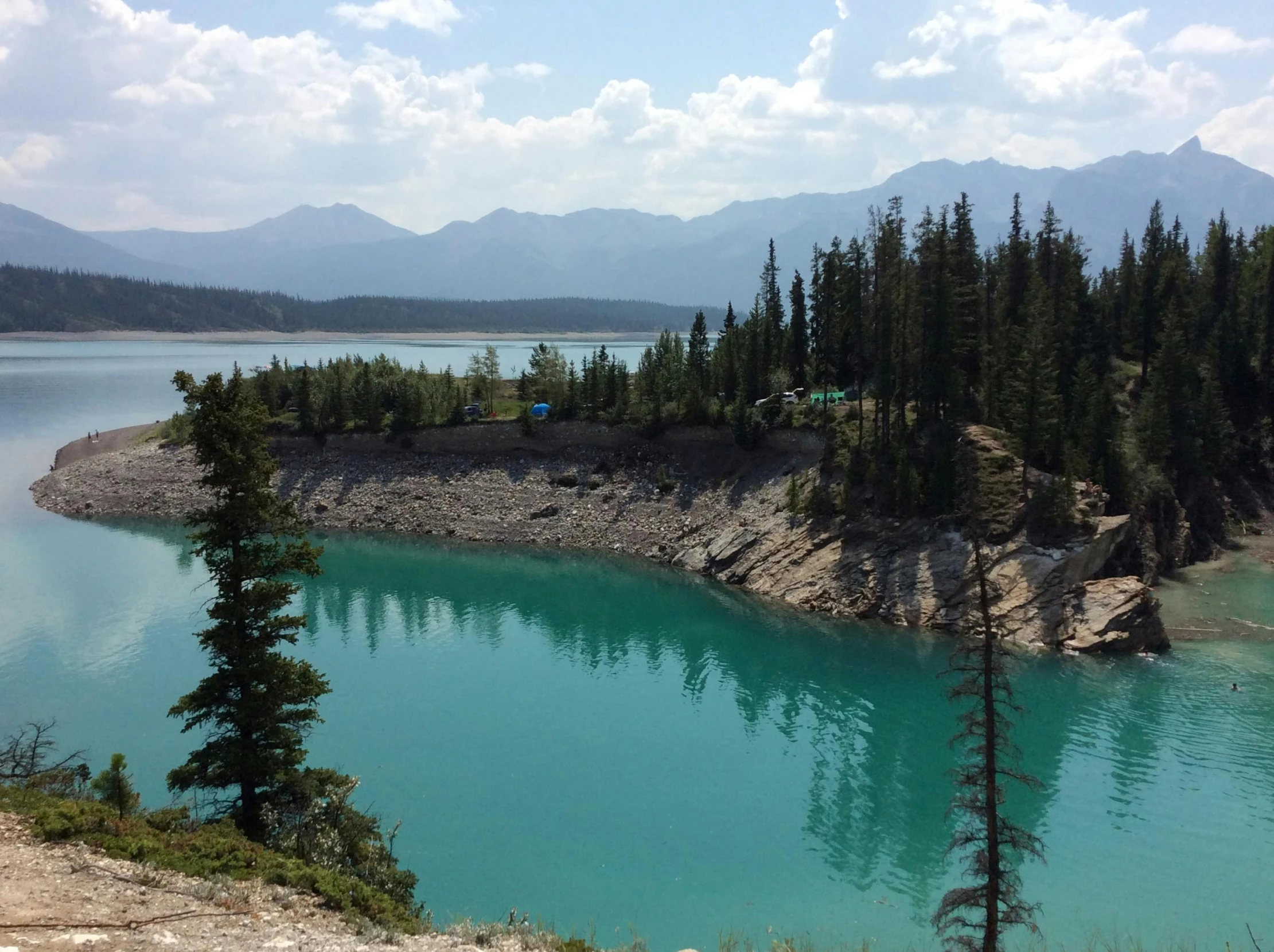 the water at the bottom of a mountain range looks quite azure