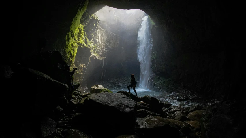 a person standing at the entrance to a cave