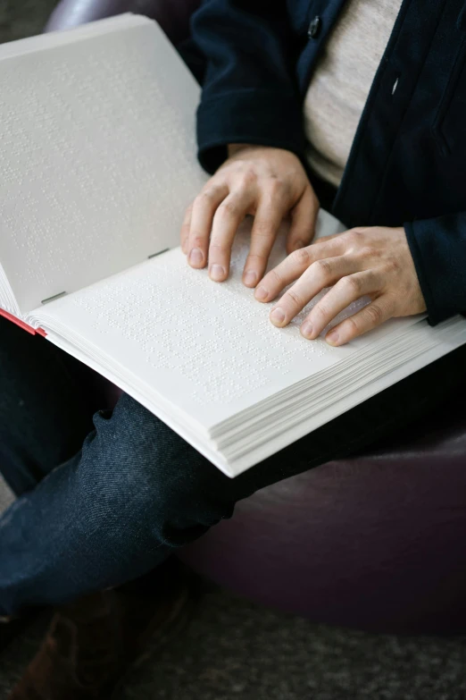 a person holding an open book and a mouse
