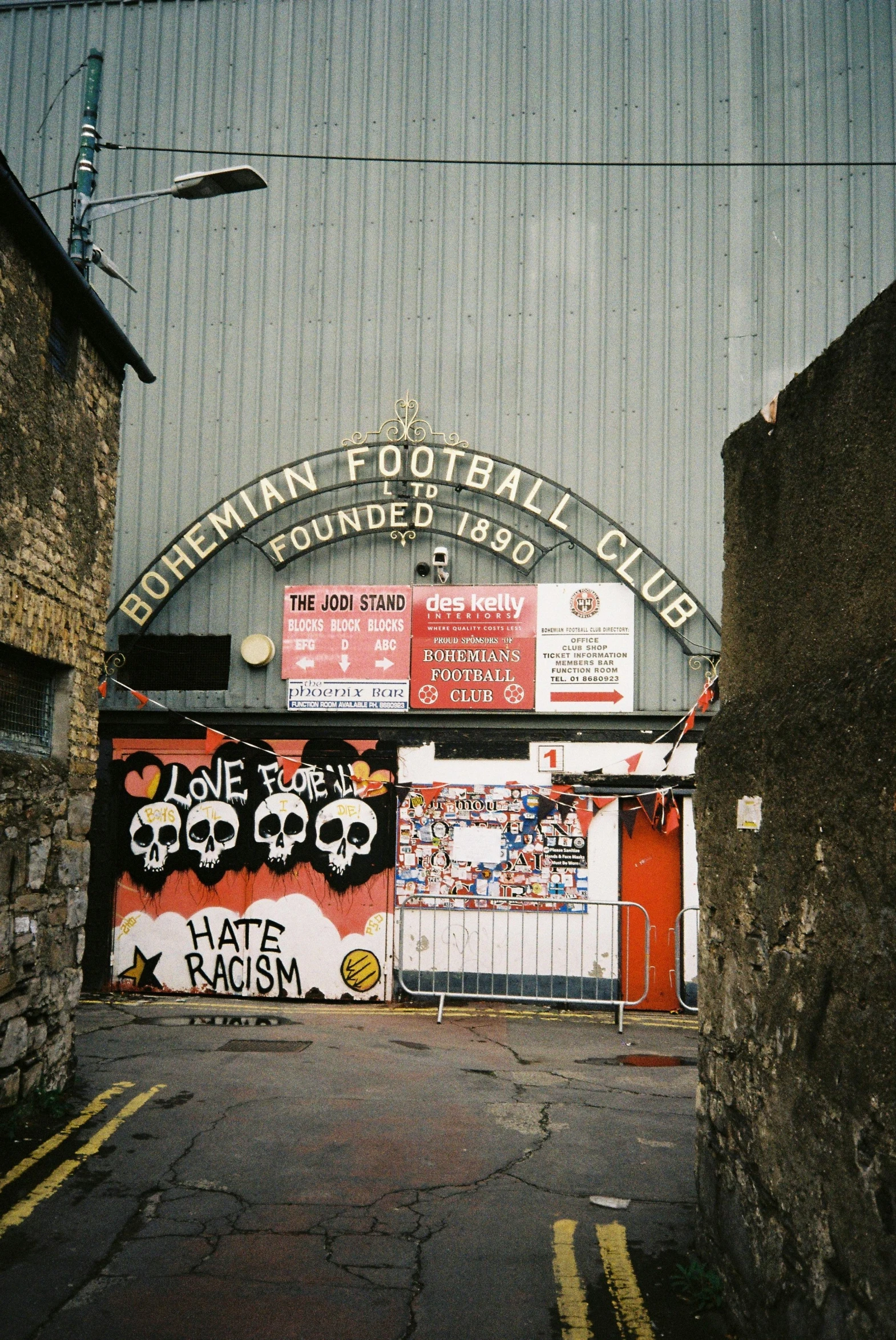 graffiti and other artwork cover the side of a football field