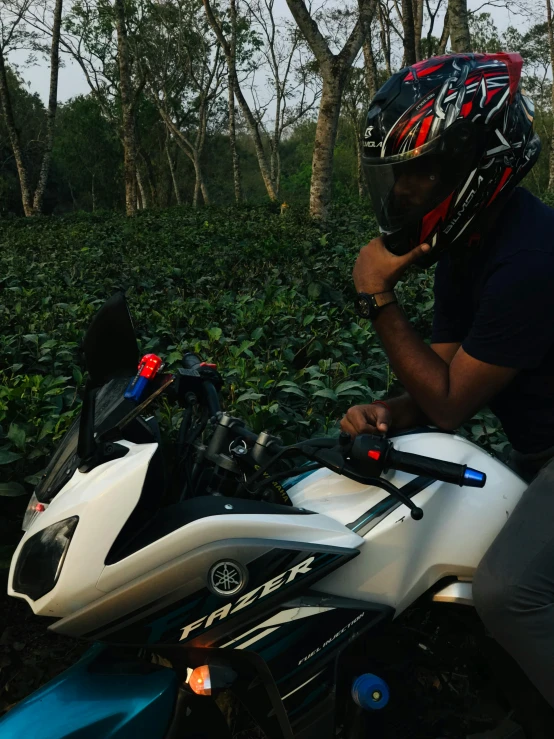 a man on a white and blue motorcycle talking on a phone